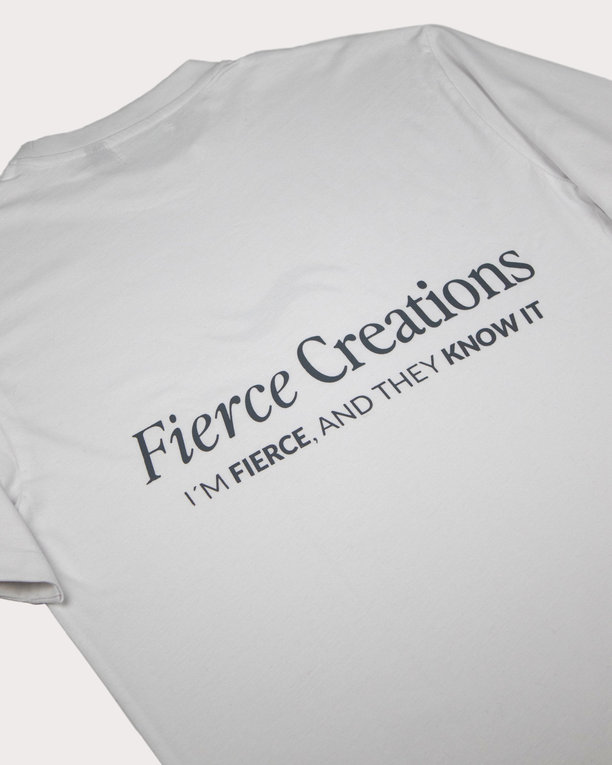 Imagen de detalle de la camiseta blanca, logotipo Fierce Creations y eslogan: I´M FIERCE, AND THEY KNOW IT